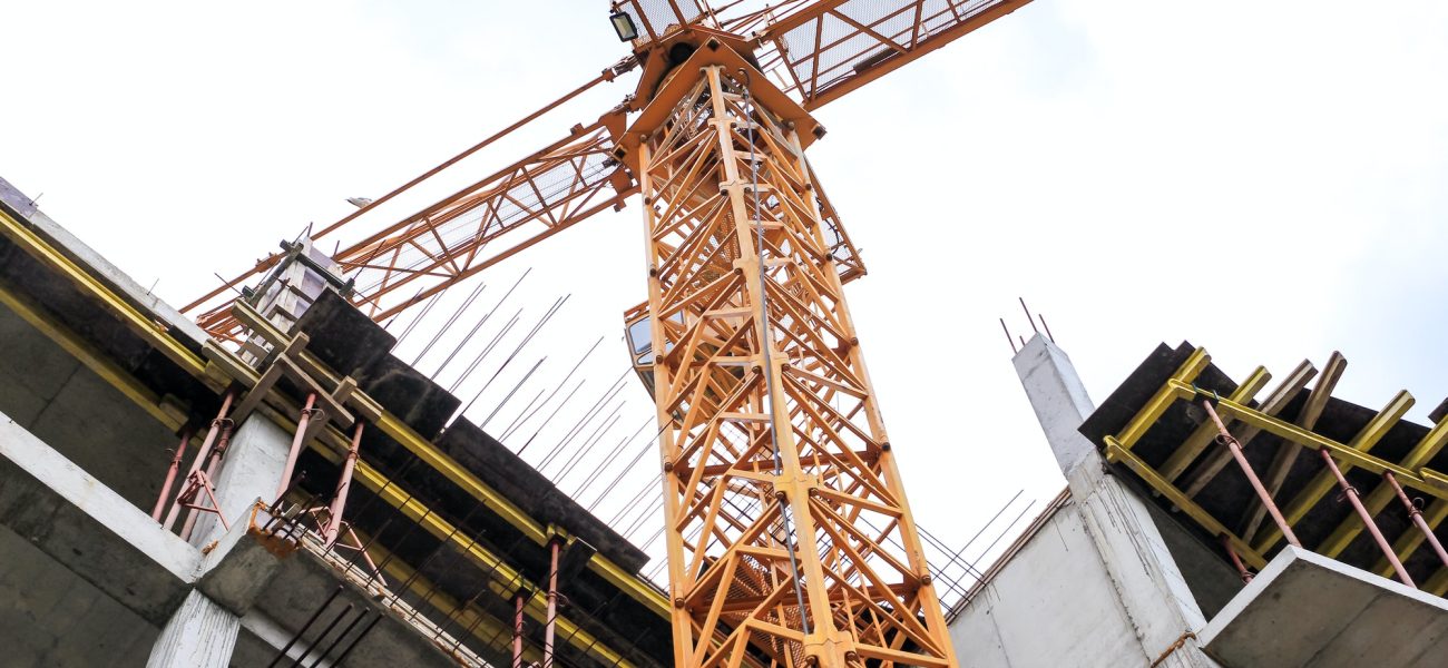 Construction crane stands on the background of the sky. Construct